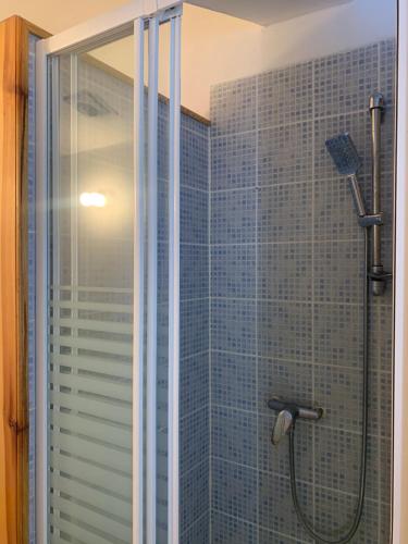 a bathroom with a shower with a glass door at Le bleu des toits in Lodève