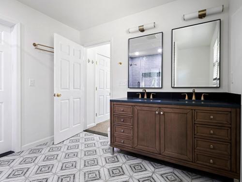 a bathroom with a wooden vanity and a mirror at Beautiful 6-Bedroom Escape Featuring a Private Pool in Hampton Bays