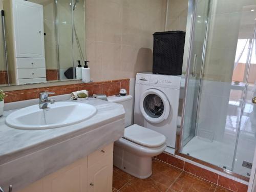 a bathroom with a sink and a washing machine at Apartamento Playaluna in Almería