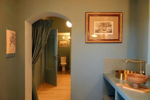 a hallway with a bathroom with a sink and a mirror at Symi Aerides Suites in Symi