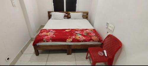 a small bedroom with a bed and a red chair at HOTEL GILL TOWER (GRAND) in Hanumāngarh