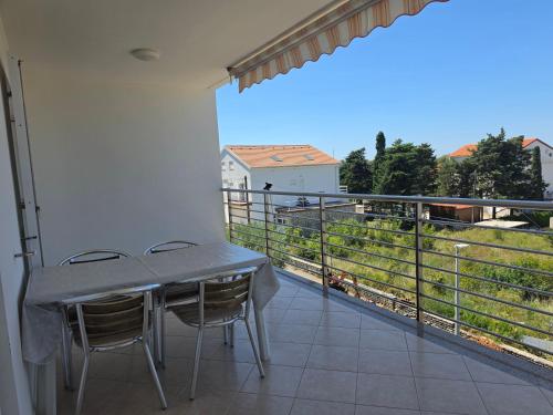 a table and chairs on a balcony with a view at Apartment Keti - Mandre in Mandre