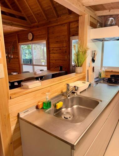 a kitchen with a stainless steel sink in a cabin at Kozakura Cottage II in Hamamatsu
