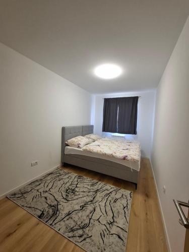 a small bedroom with a bed and a rug at Apartman THE VIEW in Vranješ