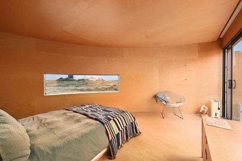 a bedroom with a bed and a table and a window at El Ray by Bloom Stays in Dungeness