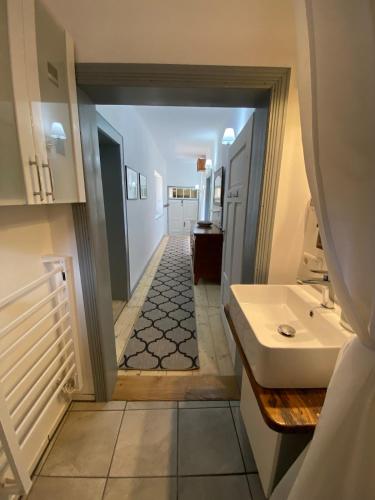 a bathroom with a sink and a hallway at Bavaria One in Cincu