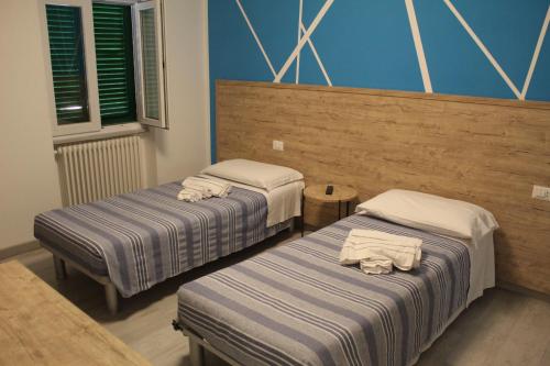 two beds in a room with blue walls at APPARTAMENTO TORRESI 2 in Ancona
