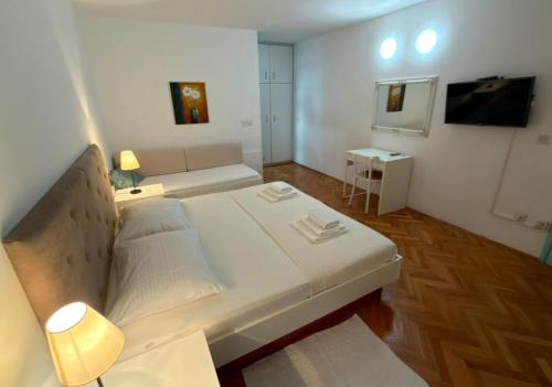 a large white bed in a room with a couch at Brela S1 S4-no parking in Brela