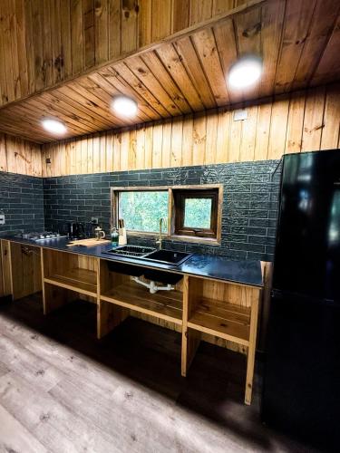 a large kitchen with a sink and a counter at Cabañas Mountain Fox in Puerto Varas
