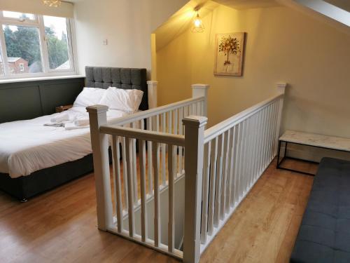 a bedroom with a bed and a stair case at Family Friendly I Pets Welcome I Short Walk to Railway Station I 10min Drive to Safari Park in Kidderminster