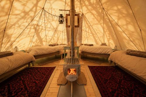ein Zimmer mit drei Betten und einem Kamin in einer Jurte in der Unterkunft Eden Baths in Averoy