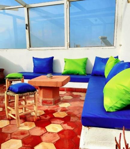 a living room with a blue couch and a table at Dar Latigeo in Essaouira