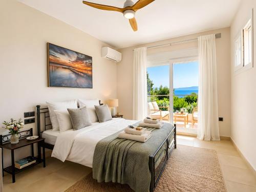 a bedroom with a bed with a view of the ocean at Nina Apartment in Ágios Márkos