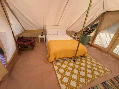 a bedroom in a tent with a bed in it at West Holme Glamping in Wareham