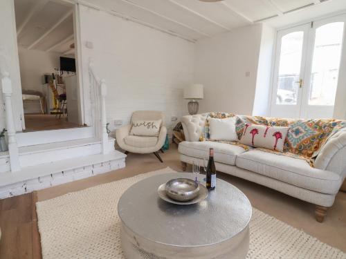 a living room with a couch and a table at The Studio Cottage in Denbigh