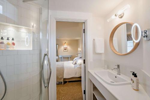 a bathroom with a sink and a mirror and a bed at Cub Bedroom Four in Eastdean