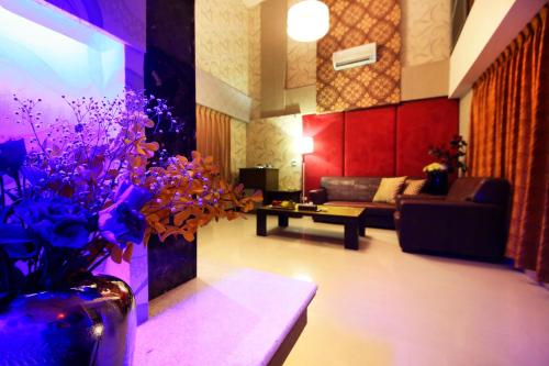 a living room with a couch and a vase with purple flowers at Wsb Motel-Rende in Tainan