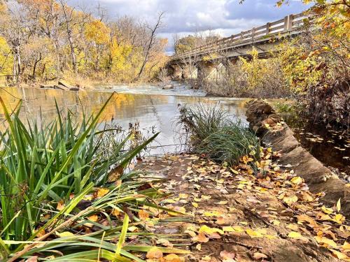 a river with a bridge and leaves on the water at S2 Ft Sill Sky Stack-City View Suite 8-NA PPI SE in Medicine Park