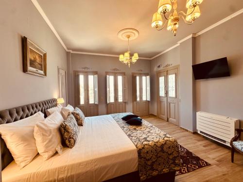 a bedroom with a large bed and a chandelier at Symi Aerides Suites in Symi