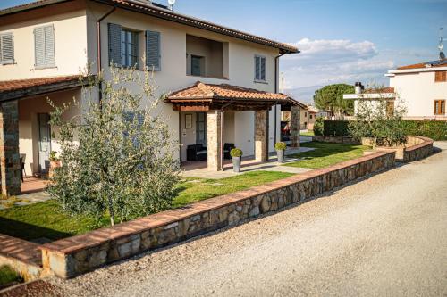 a house with a stone retaining wall next to a road at Il Cerro in Arezzo