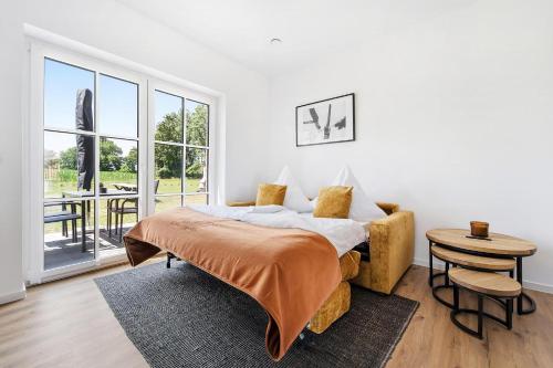 ein Schlafzimmer mit einem Bett und einem Tisch in der Unterkunft Neu! Auszeit an der "Grenzfarm" - Stilvolle und geräumige FeWo - perfekt für Radfahrer und Familien in Nordhorn