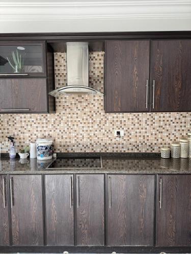 a kitchen with wooden cabinets and a counter top at Luxury Farm Villa with Private Pool in Jerash
