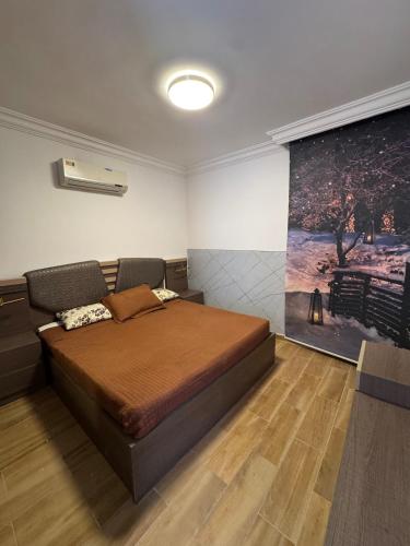 a bedroom with a bed and a painting on the wall at Luxury Farm Villa with Private Pool in Jerash