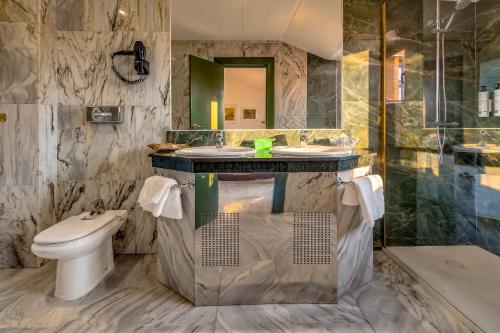 a bathroom with two sinks and a toilet at Spa Jardines de Lorca in Lorca
