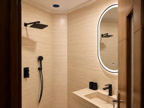 a bathroom with a shower with a sink and a mirror at Dakhla Sur Mer Hôtel in Dakhla