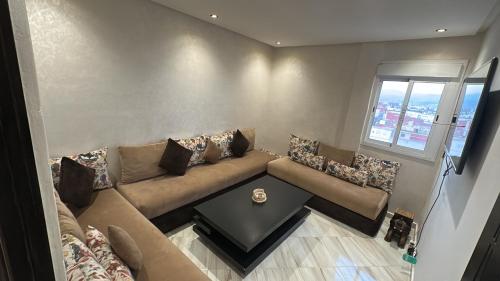 a living room with a couch and a table at Tetouan house vue- chambre climatisée in Tétouan