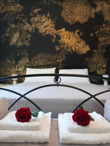 a bed with towels and two roses on it at Chimera 37 in Avezzano