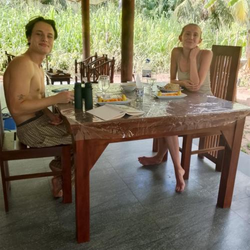 a man and a woman sitting at a table at Wilpattu Coconut Villa in Nochchiyagama
