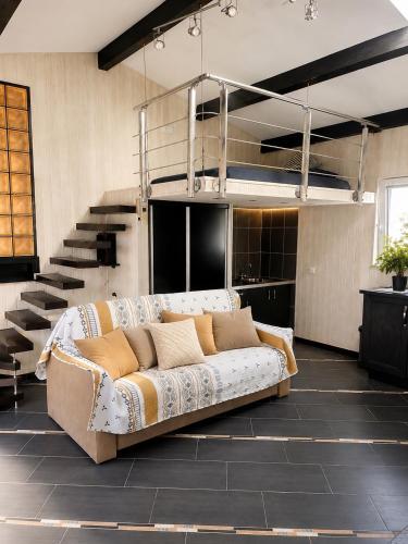 a couch in a living room with a staircase at villa plaisirs in Saint Paul de Vence