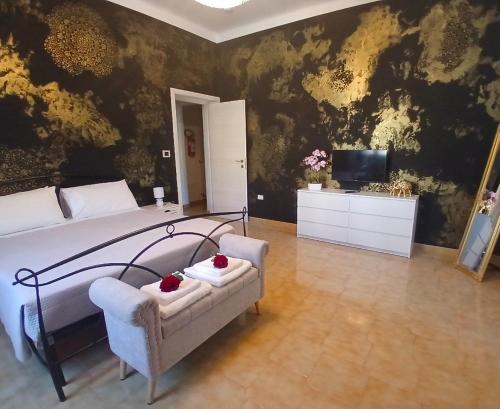 a bedroom with a bed and a chair and a television at Chimera 37's in Avezzano