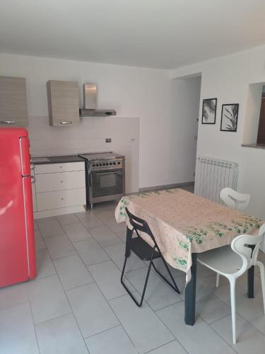 a kitchen with a table and a red refrigerator at Casa Levante in Brugnato