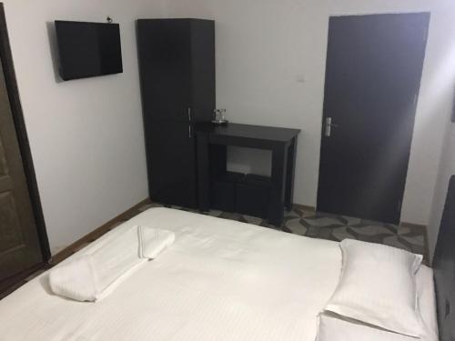 una camera con letto bianco e armadio nero di Pensiunea Marcello a Iaşi