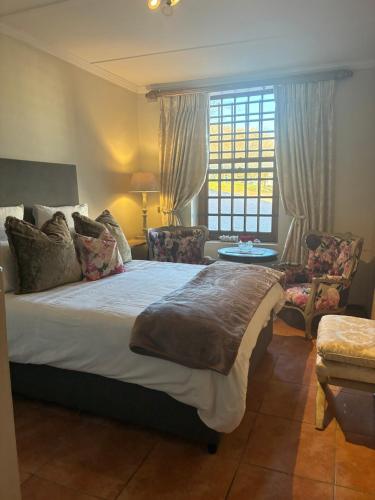 a bedroom with a large bed and a window at Rose Cottage De Hoop Farm PAARL SOUTH in Hartebeeskraal