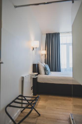 a bedroom with a bed with a window and a desk at Shelter-rooms in Buysinghen