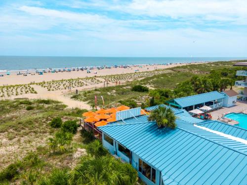 a building with a blue roof next to a beach at The Gardens 703 in Tybee Island