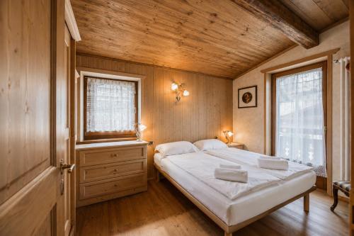 a bedroom with a large bed and a window at Cesa Linda by AMA Val di Fassa in Campitello di Fassa