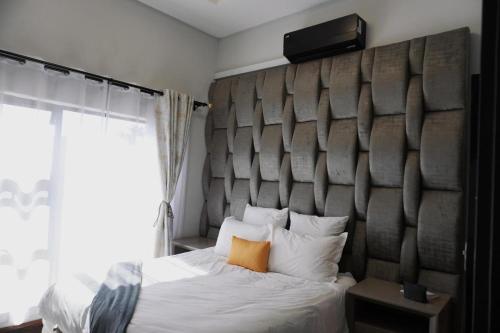 a bedroom with a bed with a large headboard at Big Mo Bev and Grill in Middelburg