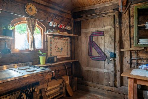 a kitchen with wooden walls and a table and a window at Etno Kuca Bajka in Mataruška Banja
