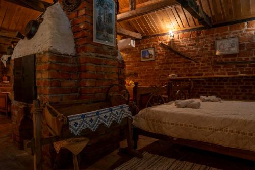 a bedroom with a bed and a brick wall at Etno Kuca Bajka in Mataruška Banja