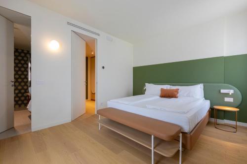 a bed in a room with a green wall at Borgo di Lazise - Adults friendly in Lazise