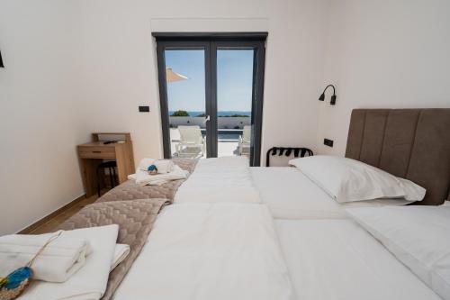 a row of white beds in a room with a view at Villa Meritus in Gramače