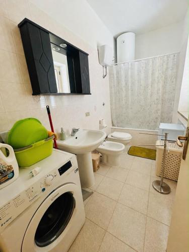 a bathroom with a washing machine and a sink at Casa Vacanza Aria di Mare in Policoro