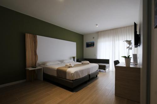 a bedroom with a bed and a green wall at Hotel Olivò in Bitritto