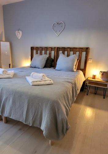 a bedroom with a large bed with towels on it at Clos De La Ronziere Avec Jacuzzi in Soulages