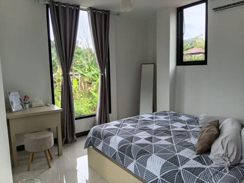 a bedroom with a bed and a large window at Villa Droom Nest Manado in Manado