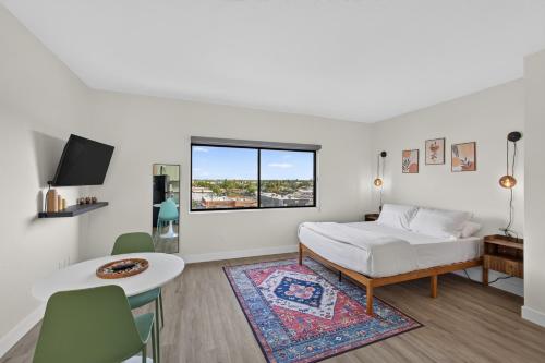 a white bedroom with a bed and a table and chairs at Astral Desert Retreats in Mesa